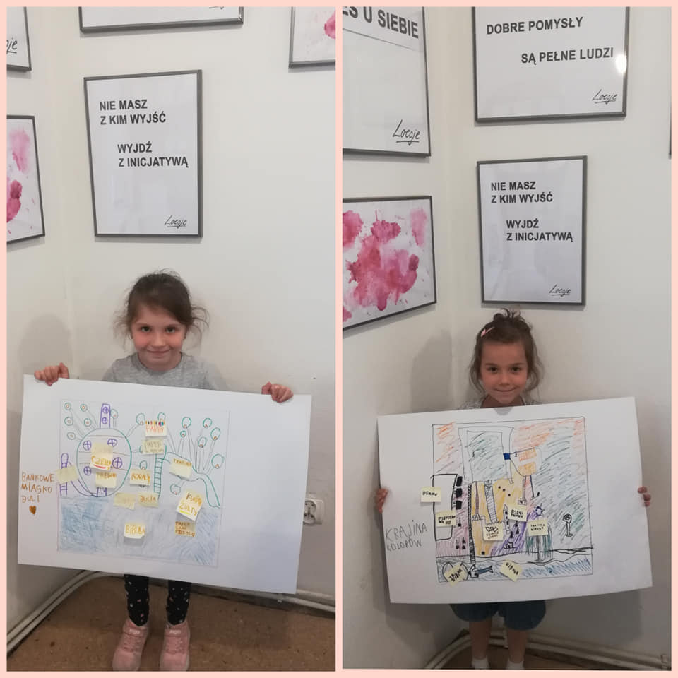Dwie dziewczynki trzymają plansze z planem stworzonych przez nie miast